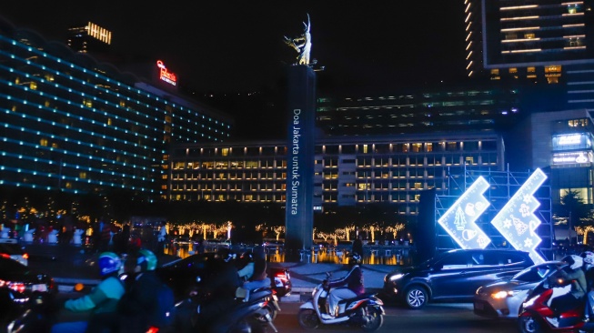 Instalasi Video Mapping pada Patung Selamat Datang saat Jakarta Light Festival 2025 di kawasan Bundaran HI, Jakarta, Selasa (23/12/2025). [Suara.com/Alfian Winanto]
