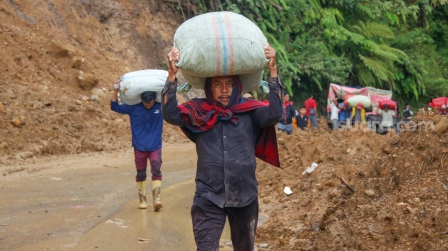 Sejumlah warga menyeberang sungai melalui jembatan darurat di wilayah Tenge Besi, Kecamatan Pintu Rime Gayo, Kabupaten Bener Meriah, Aceh. [Khalis Surry/Suara.com].
