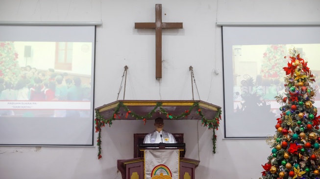 Umat Kristiani melakukan ibadah misa malam Natal di Gereja Tugu, Semper, Jakarta Utara, Selasa (24/12/2025). [Suara.com/Alfian Winanto]