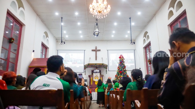 Umat Kristiani melakukan ibadah misa malam Natal di Gereja Tugu, Semper, Jakarta Utara, Selasa (24/12/2025). [Suara.com/Alfian Winanto]