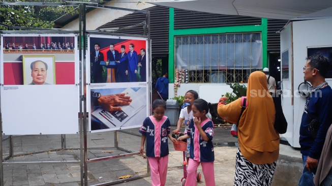 Wisatawan melihat karya foto pada pameran Haluan Merah Putih di Taman Margasatwa Ragunan (TMR) di Jakarta, Kamis (25/12/2025). [Suara.com/Alfian Winanto]
