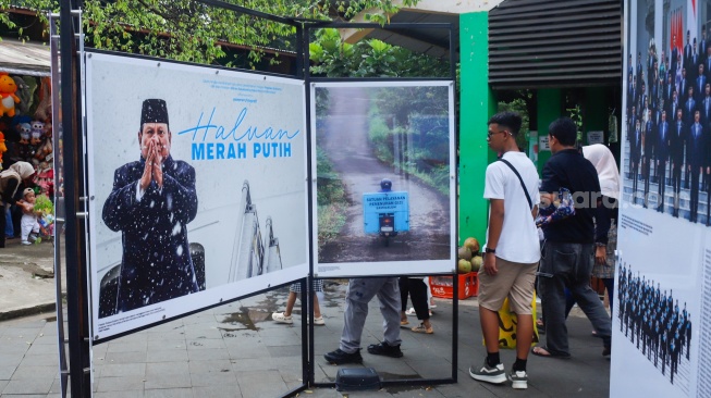 Wisatawan melihat karya foto pada pameran Haluan Merah Putih di Taman Margasatwa Ragunan (TMR) di Jakarta, Kamis (25/12/2025). [Suara.com/Alfian Winanto]

