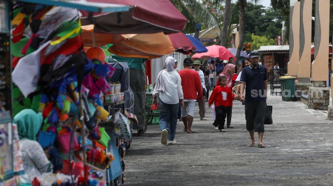 Pengunjung berwisata di Pantai Lagoon, Taman Impian Jaya Ancol, Jakarta, Jumat (26/12/2025). [Suara.com/Alfian Winanto]