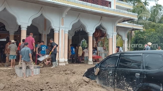 Warga Gampong Kubu Kecamatan Peusangan Siblah Krueng, Kabupaten Bireuen, bergotong royong membersihkan meunasah dari lumpur yang terbawa banjir. [dokumentasi warga]