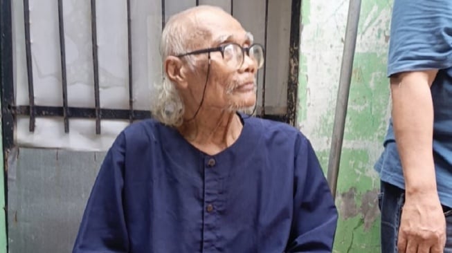 Didin Boneng hanya bisa meratap sedih usai rumahnya di kawasan Matraman, Jakarta Timur hancur usai diterpa hujan deras sejak Minggu (28/12/2025). [istimewa]