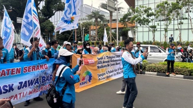 Sejumlah massa buruh yang tergabung dalam Konferensi Serikat Pekerja Indonesia (KSPI) kembali turun ke jalan untuk menyuarakan tuntutan mereka di jantung ibu kota, Selasa (30/12/2025). (Suara.com/Faqih)
