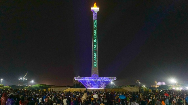 Pengunjung menikmati sajian video mapping di kawasan Monas, Jakarta, Kamis (1/1/2026). [ANTARA FOTO/Ika Maryani/wpa]