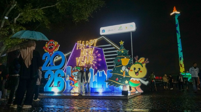 Pengunjung berfoto dengan ornamen tahun baru di kawasan Monas, Jakarta, Rabu (31/12/2025). [ANTARA FOTO/Ika Maryani/wpa]