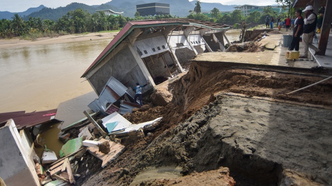 Warga menyelamatkan bagian bangunan Taman Pendidikan Al-Quran di kawasan Masjid Jamaatul Yaqin Banda Cino, Talao Mundam, Nagari Katapiang, Padang Pariaman, Sumatera Barat, Minggu (4/1/2026). [ANTARA FOTO/Iggoy el Fitra/nym]