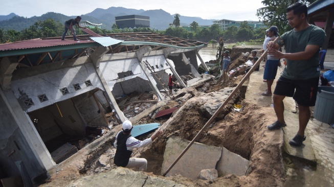 Warga menyelamatkan bagian bangunan Taman Pendidikan Al-Quran di kawasan Masjid Jamaatul Yaqin Banda Cino, Talao Mundam, Nagari Katapiang, Padang Pariaman, Sumatera Barat, Minggu (4/1/2026). [ANTARA FOTO/Iggoy el Fitra/nym]