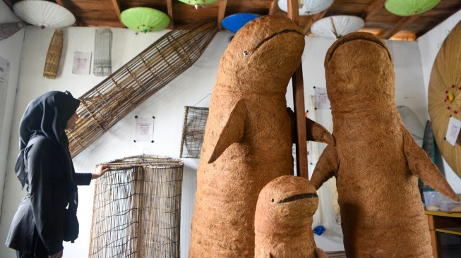 Pengunjung mengamati koleksi dari Museum Pela di kawasan konservasi Pesut Mahakam di Desa Wisata Pela di Kutai Kartanegara, Kalimantan Timur, Minggu (4/1/2026). [ANTARA FOTO/M Risyal Hidayat/YU]