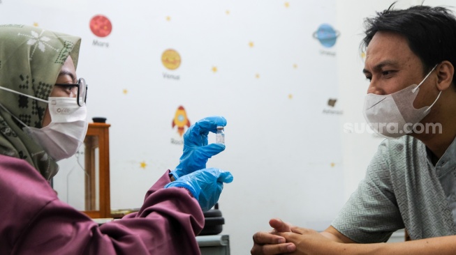 Dokter memberikan informask vaksin influenza Flubio kepada pasien di Klinik Pratama Dermaga Raya, Jakarta, Rabu (7/1/2026). [Suara.com/Alfian Winanto]