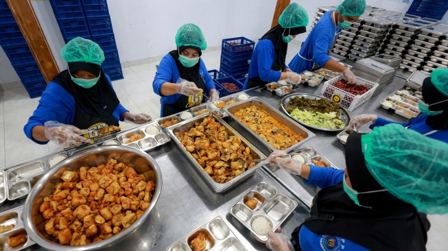 Sejumlah pekerja menyiapkan paket makanan untuk program makan bergizi gratis (MBG) di dapur Satuan Pelayanan Pemenuhan Gizi (SPPG) Dipan Tanjunganom, Nganjuk, Jawa Timur, Kamis (8/1/2026). [ANTARA FOTO/Muhammad Mada/nz]
