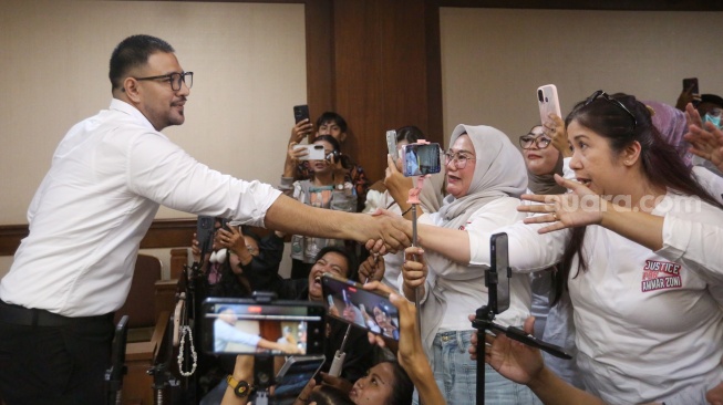 Terdakwa kasus peredaran narkotika di dalam Rutan Salemba, Ammar Zoni menyapa penggemarnya saat menjalani sidang lanjutan di Pengadilan Negeri Jakarta Pusat, Jakarta, Kamis (8/1/2026). [Suara.com/Alfian Winanto]
