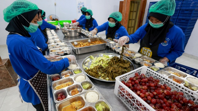 Sejumlah pekerja menyiapkan paket makanan untuk program makan bergizi gratis (MBG) di dapur Satuan Pelayanan Pemenuhan Gizi (SPPG) Dipan Tanjunganom, Nganjuk, Jawa Timur, Kamis (8/1/2026). [ANTARA FOTO/Muhammad Mada/nz]