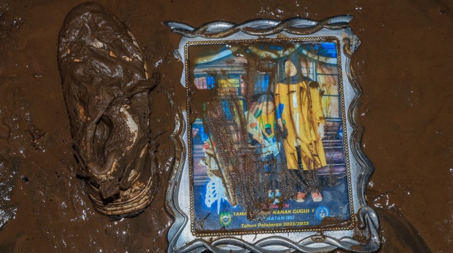 Sebuah foto dan sepatu tergeletak di dalam rumah warga yang dipenuhi lumpur pascabanjir di Desa Tongute Ternate asal Kabupaten Halmahera Barat, Maluku Utara, Kamis (8/1/2026). [ANTARA FOTO/Andri Saputra/tom]