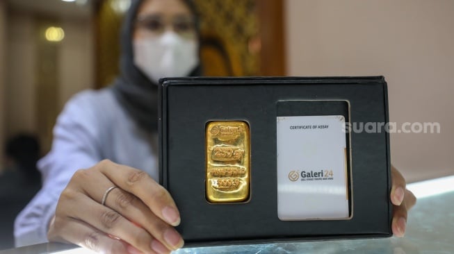 Pramuniaga menunjukkan emas batangan di sebuah gerai Galeri 24, Jakarta, Jumat (9/1/2026). [Suara.com/Alfian Winanto]