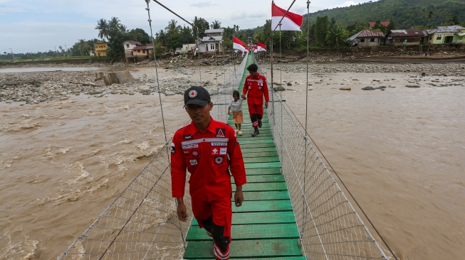 Pelajar melintas di atas jembatan gantung yang baru selesai pembangunannya di Meureudu, Pidie Jaya, Aceh, Jumat (9/1/2026). [ANTARA FOTO/Irwansyah Putra/bar] 