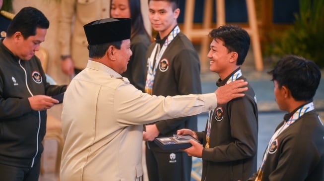 Presiden Prabowo Subianto (kedua kiri) didampingi Menpora Erick Thohir (kiri) menyerahkan buku tabungan kepada atlet skateboard Basral Graito (kedua kanan) saat penyerahan bonus kepada atlet peraih medali pada SEA Games Thailand di Istana Negara, Jakarta, Kamis (8/1/2025). [ANTARA FOTO/Hafidz Mubarak A/foc]