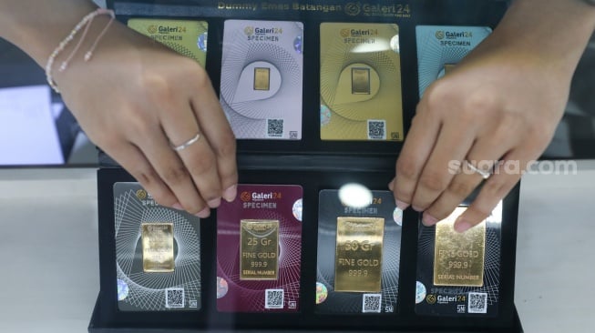 Pramuniaga menunjukkan emas batangan di sebuah gerai Galeri 24, Jakarta, Jumat (9/1/2026). [Suara.com/Alfian Winanto]