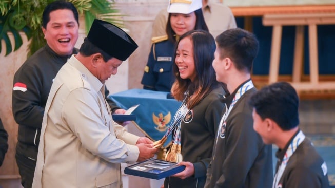 Presiden Prabowo Subianto (kedua kiri) didampingi Menpora Erick Thohir (kiri) menghitung medali yang diraih atlet triathlon Martina Ayu Pratiwi (ketiga kanan) saat menyerahkan bonus kepada atlet peraih medali pada SEA Games Thailand di Istana Negara, Jakarta, Kamis (8/1/2025). [ANTARA FOTO/Hafidz Mubarak A/foc]