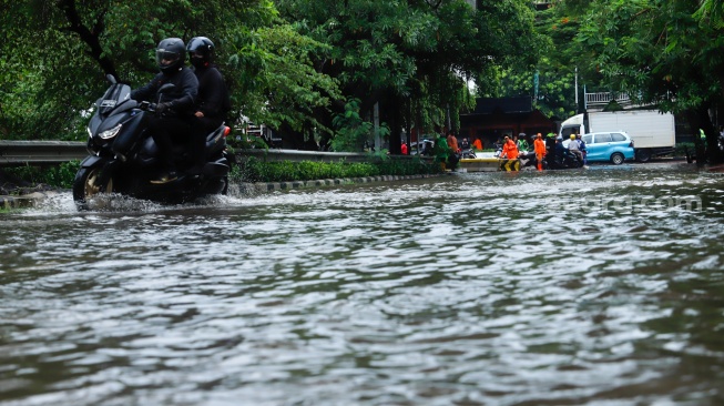 Pengendara motor menorobos banjir yang menggenang di Jalan Danau Sunter Raya, Jakarta, Senin (12/1/2026). [Suara.com/Alfian Winanto]