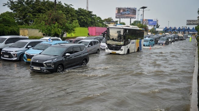 Sejumlah kendaraan melintas saat banjir di Jalan Tol Sedyatmo, Cengkareng, Jakarta, Senin (12/1/2026). [ANTARA FOTO/Putra M. Akbar/nz]