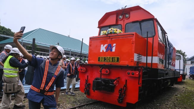 Anggota komunitas penggemar kereta api (railfans) berswafoto di depan lokomotif BB3068414 vintage livery usai diresmikan di Balai Yasa Manggarai, Jakarta, Rabu (14/1/2025). [ANTARA FOTO/Hafidz Mubarak A/foc]