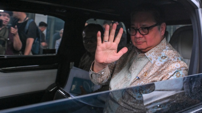 Menko Perekonomian Airlangga Hartarto melambaikan tangannya di dalam mobil usai membahas kajian pencegahan korupsi di Gedung Merah Putih KPK, Jakarta, Rabu (14/1/2026). [ANTARA FOTO/Hafidz Mubarak A/foc]