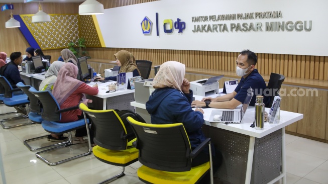 Petugas melayani wajib pajak di Kantor Pelayanan Pajak (KPP) Pratama Jakarta Pasar Minggu, Rabu (14/1/2026). [Suara.com/Alfian Winanto]