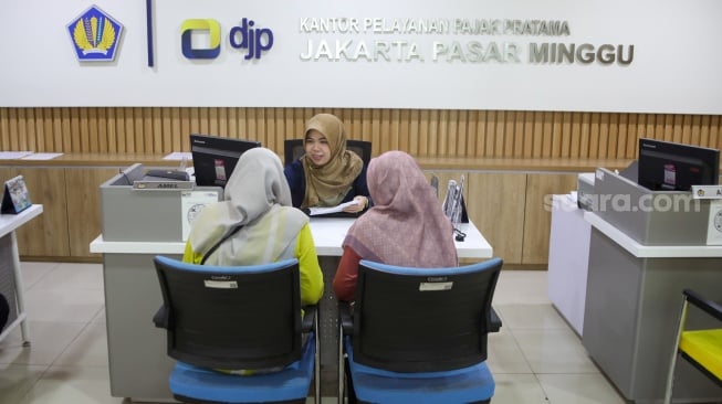 Petugas melayani wajib pajak di Kantor Pelayanan Pajak (KPP) Pratama Jakarta Pasar Minggu, Rabu (14/1/2026). [Suara.com/Alfian Winanto]