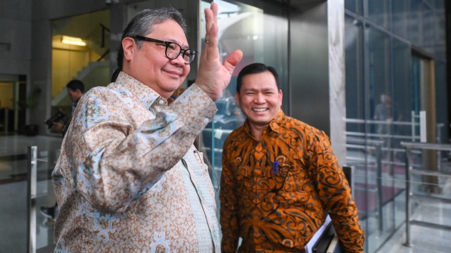 Menko Perekonomian Airlangga Hartarto (kiri) melambaikan tangan saat tiba untuk membahas kajian pencegahan korupsi di Gedung Merah Putih KPK, Jakarta, Rabu (14/1/2026). [ANTARA FOTO/Hafidz Mubarak A/foc]