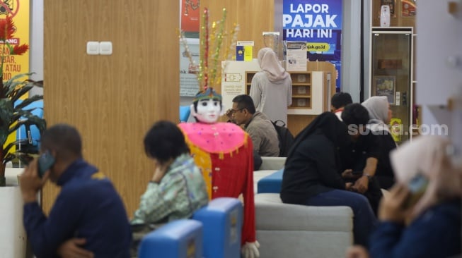 Petugas melayani wajib pajak di Kantor Pelayanan Pajak (KPP) Pratama Jakarta Pasar Minggu, Rabu (14/1/2026). [Suara.com/Alfian Winanto]