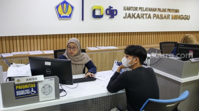Petugas melayani wajib pajak di Kantor Pelayanan Pajak (KPP) Pratama Jakarta Pasar Minggu, Rabu (14/1/2026). [Suara.com/Alfian Winanto]