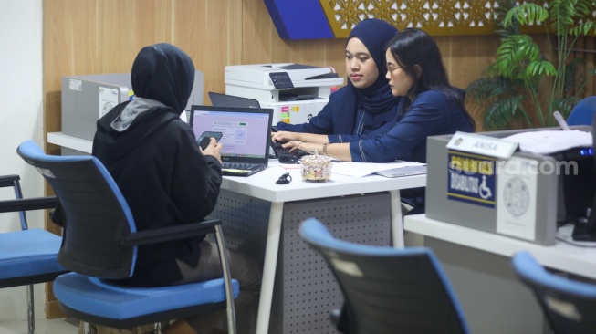 Petugas melayani wajib pajak di Kantor Pelayanan Pajak (KPP) Pratama Jakarta Pasar Minggu, Rabu (14/1/2026). [Suara.com/Alfian Winanto]