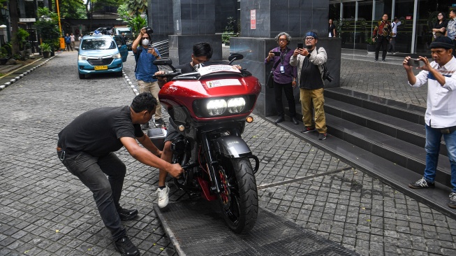 Petugas menurunkan barang bukti berupa sepeda motor Harley Davidson untuk Terdakwa kasus dugaan suap terhadap putusan lepas perkara korupsi pemberian fasilitas ekspor minyak sawit mentah (CPO) Ariyanto Bakri dan Marcella Santoso di Pengadilan Tipikor, Jakarta, Rabu (14/1/2026). [ANTARA FOTO/Muhammad Adimaja/foc]