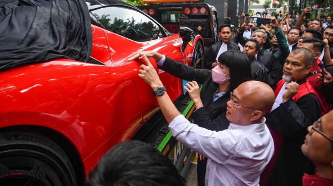 Hakim ketua Tipikor Efendi (kanan) memeriksa barang bukti berupa mobil Ferrari untuk terdakwa kasus dugaan suap terhadap putusan lepas perkara korupsi pemberian fasilitas ekspor minyak sawit mentah (CPO) Ariyanto Bakri (kiri) dan Marcella Santoso (tengah) di Pengadilan Tipikor, Jakarta, Rabu (14/1/2026). [ANTARA FOTO/Muhammad Adimaja/foc]