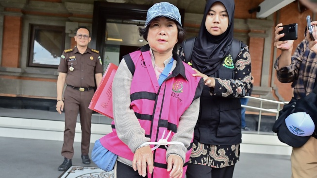 Petugas menggiring buronan terpidana kasus korupsi pemberian kredit fiktif Mila Indriani Notowibowo (tengah) di Kantor Kejaksaan Tinggi Bali, Denpasar, Bali, Rabu (14/1/2026). [ANTARA FOTO/Fikri Yusuf/foc]