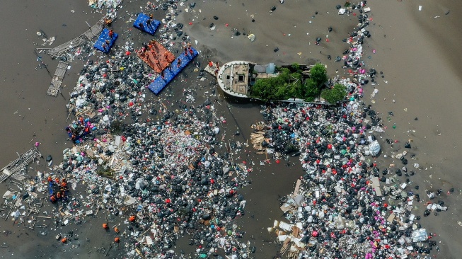 Foto udara petugas mengangkut sampah di kawasan Muara Baru, Jakarta, Jumat (16/1/2026). [ANTARA FOTO/Sulthony Hasanuddin/bar]