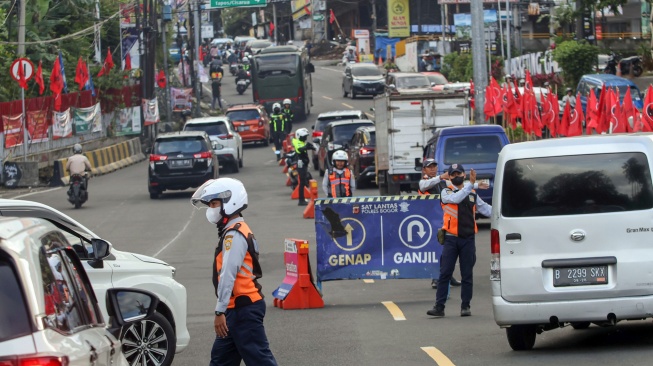 Petugas Sat Lantas Polres Bogor bersama petugas Dishub Kabupaten Bogor mengarahkan kendaraan wisatawan saat penyekatan kendaraan nomor polisi ganjil genap di jalur wisata Puncak, Gadog, Kabupaten Bogor, Jawa Barat, Jumat (16/1/2026). [ANTARA FOTO/Yulius Satria Wijaya/bar]