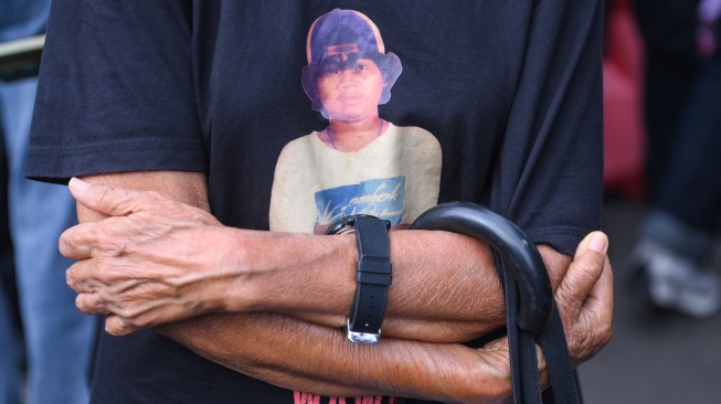 Ibunda dari korban Semanggi I Benardinus Realino Norma Irawan atau Wawan, Maria Katarina Sumarsih mengenakan kaos bergambar anaknya saat mengikuti aksi Kamisan ke-893 di depan Istana Merdeka, Jakarta, Kamis (15/1/2026). [ANTARA FOTO/Hafidz Mubarak A/rwa]