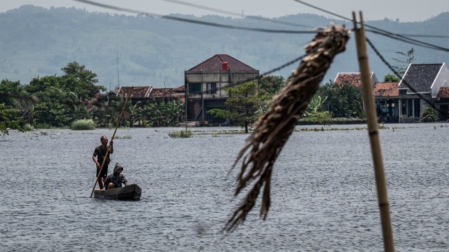 Warga menggunakan rakit untuk menyeberangi akses jalan yang terendam banjir di Desa Mejobo, Kudus, Jawa Tengah, Senin (19/1/2026). [ANTARA FOTO/Aprillio Akbar/rwa]