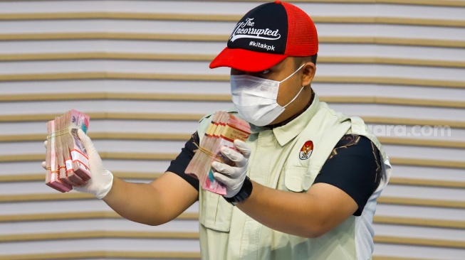 Petugas menunjukan barang bukti hasil Operasi Tangkap Tangan (OTT) terkait fee proyek dan dana CSR di wilayah Madiun saat Konferensi Pers di Gedung Merah Putih KPK, Jakarta, Selasa (20/1/2026). [Suara.com/Alfian Winanto]