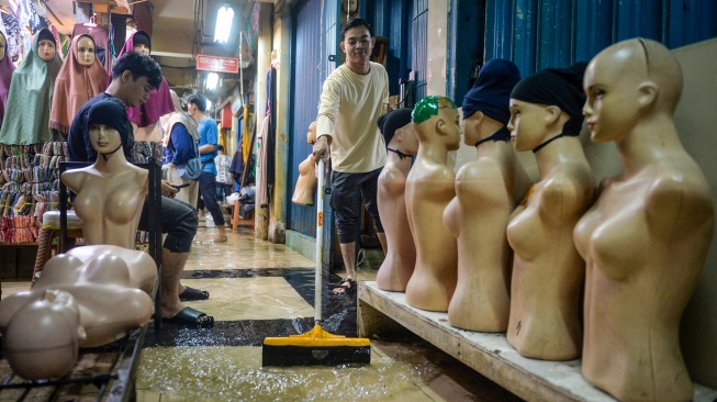Pedagang membersihkan genangan air di Pasar Cipulir, Jakarta, Kamis (22/1/2026). [ANTARA FOTO/Putra M. Akbar/agr]