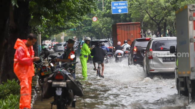 Warga beraktivitas di tengah genangan banjir yang merendam di sekitar Cempaka Putih, Jakarta, Kamis (22/1/2026). [Suara.com/Alfian Winanto]
