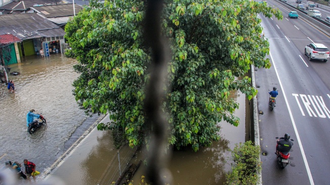 Warga mendorong sepeda motornya di jalan yang terendam banjir di Jalan Outer Ring Road, Cengkareng, Jakarta, Jumat (23/1/2026). [ANTARA FOTO/Naufal Khoirulloh/foc]