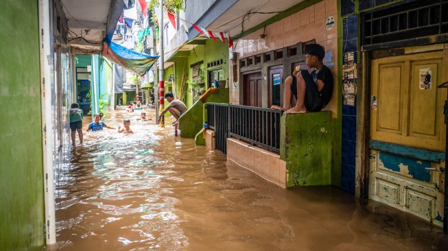 Warga berada di rumah saat banjir merendam perkampungan di Kebon Pala, Jatinegara, Jakarta, Jumat (23/1/2026). [ANTARA FOTO/Bayu Pratama S/foc]
