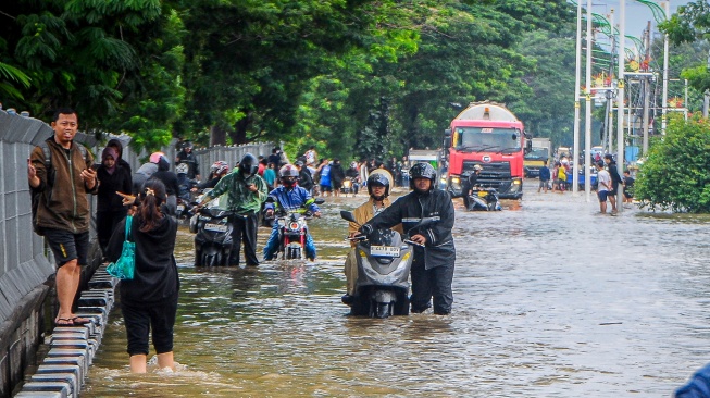 Warga mendorong sepeda motornya di jalan yang terendam banjir di Jalan Outer Ring Road, Cengkareng, Jakarta, Jumat (23/1/2026). [ANTARA FOTO/Naufal Khoirulloh/foc]