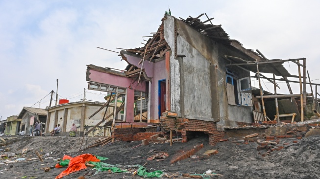 Sejumlah warga duduk dekat rumah yang rusak diterjang gelombang tinggi di pesisir kampung nelayan, Lingkungan Bugis, Ampenan, Mataram, NTB, Senin (26/1/2026). [ANTARA FOTO/Ahmad Subaidi/nz]
