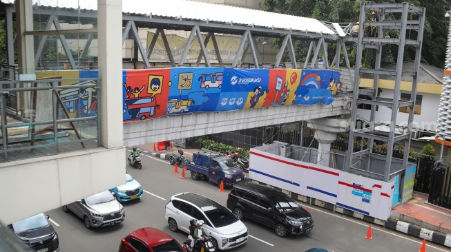 Pekerja menyelesaikan pembangunan Jembatan Penyeberangan Orang (JPO) Sarinah, Jakarta Pusat, Senin (26/1/2026). [Suara.com/Alfian Winanto]